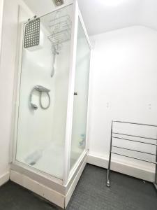 a glass shower in a room with a bench at Grace Apartments - Living Spring 1 in Ashford