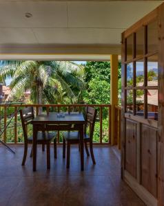 
a person sitting at a table in front of a patio at Dream Holiday Self Catering in La Digue

