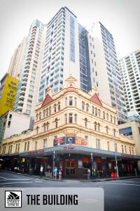 a building on a city street with tall buildings at Sydney Central Inn in Sydney