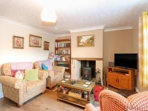 sala de estar con 2 sofás y chimenea en Rose Cottage, en Stoke Ferry