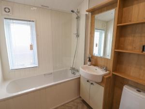 a bathroom with a tub and a sink and a bath tub at Sea Holly Lodge in Saltburn-by-the-Sea +14 photos