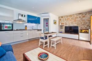 Una cocina y una sala de estar con mesa y sillas. en Villa Don Dan, en Žrnovnica