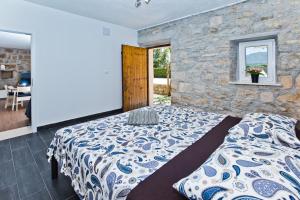 Un dormitorio con una cama y una pared de piedra. en Villa Don Dan, en Žrnovnica 35 fotos más