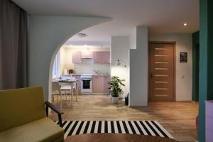 a living room with an archway leading to a kitchen at Forrest Visaginas - Studio apartment in Visaginas