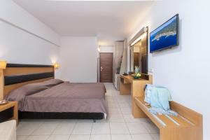 a bedroom with a bed and a tv on a wall at Lagomandra Hotel and Spa in Lagomandra
