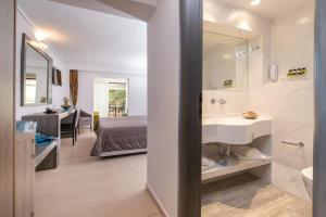 a bathroom with a sink and a bed and a mirror at Lagomandra Hotel and Spa in Lagomandra