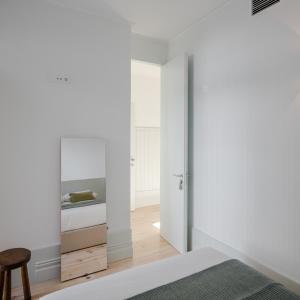 Schlafzimmer mit weißen Wänden, einem Bett und einem Spiegel in der Unterkunft Oporto Cozy & Comfy in Porto