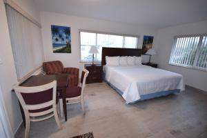 a bedroom with a bed and a chair at Surf Side Resort in Pompano Beach