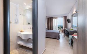a bathroom with a sink and a bedroom with a bed at Lagomandra Hotel and Spa in Lagomandra