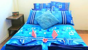 een bed met een blauw dekbed en kussens bij Cuarto entrada independiente privado solo para ti narvarte roma valle cerca Hospitales Centro Médico SXXI y Macgregor Regional IMSS 1 Parque Delta Narvarte WTC in Mexico-Stad