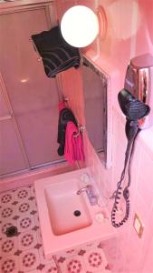 een roze badkamer met een wastafel en een telefoon bij Cuarto entrada independiente privado solo para ti narvarte roma valle cerca Hospitales Centro Médico SXXI y Macgregor Regional IMSS 1 Parque Delta Narvarte WTC in Mexico-Stad