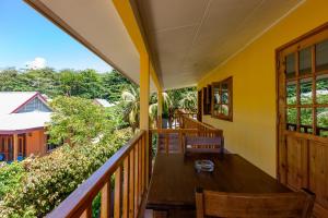 a balcony with a wooden table and chairs at Dream Holiday Self Catering in La Digue