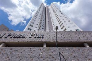un edificio blanco alto con un letrero. en Aqui você se hospeda e garante total privacidade, além de conforto, praticidade e segurança, en Curitiba