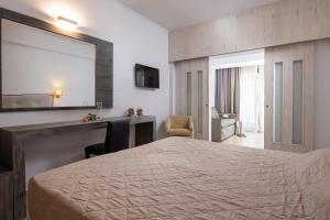 a hotel room with a bed and a mirror at Lagomandra Hotel and Spa in Lagomandra