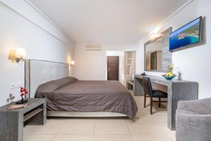 a bedroom with a bed and a table and a desk at Lagomandra Hotel and Spa in Lagomandra