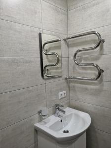 a bathroom with a sink and a mirror at НОВАЯ КВАРТИРА на пр. Соборном возле ЗНУ in Zaporozhye