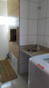 a small kitchen with a sink and a stove at Edificio Freitas in Imbituba