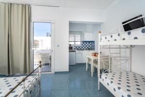 a bedroom with a bunk bed and a kitchen at Mediterraneo Apartments in Archangelos