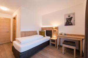 a small bedroom with a bed and a desk at Chalet Rosanna in Sankt Anton am Arlberg