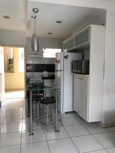 a kitchen with a table and a refrigerator at Casa de Fábio in Porto Seguro