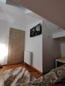 a bedroom with a bed and a tv on the wall at Duh Zlatara in Nova Varoš