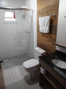 a bathroom with a toilet and a shower and a sink at Pousada Genial in Gramado +21 photos