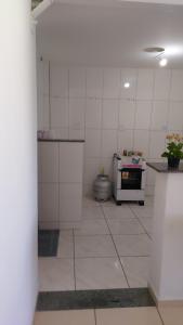 a kitchen with white tile walls and a stove at Barato e confortável AP 104 in Novo Horizonte