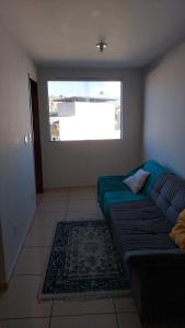 a living room with a couch and a window at Barato e confortável AP 104 in Novo Horizonte