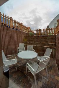 a table and chairs on a patio with a fence at 105 m2 Arbeiterwohnung mit 2 extra Schlafzimmern für 7 Personen in Wörrstadt