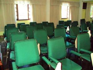 an empty room with green chairs and windows at Gallardin Palace Hotel in Petrópolis +94 photos