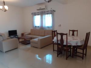a living room with a couch and a table and chairs at Les pélerins in Pointe-Noire