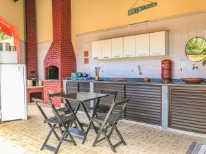 a kitchen with a table and chairs and a refrigerator at Pousada Maktüb in Peruíbe