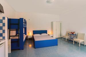 a bedroom with a blue bed and bunk beds at Mediterraneo Apartments in Archangelos