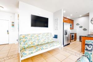 Una sala de estar con un sofá y un televisor en una pared. en Peaceful at the Pointe, en Galveston