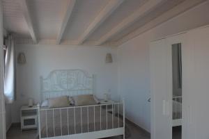 a white bedroom with a crib in a room at Villa coralin in Morro del Jable