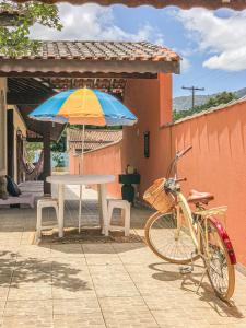 ein Fahrrad neben einem Tisch und einem Regenschirm in der Unterkunft Pousada Maktüb in Peruíbe