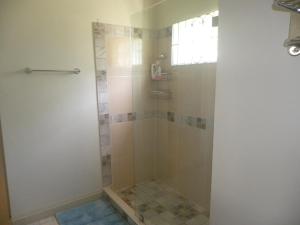 um chuveiro com uma porta de vidro na casa de banho em Ultimate Chill Montego Bay em Montego Bay