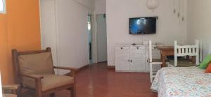 1 dormitorio con mesa y TV en la pared en a 100mts de la PLAYA "Mar y Vida" en Pinamar