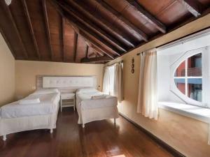 1 Schlafzimmer mit 2 Betten und 2 Fenstern in der Unterkunft Belvilla by OYO La Vicar a La Buhardilla 2 pax in La Laguna