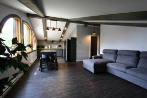 a living room with a couch and a table at Le Nid doré sur le lac (Golden Nest on the lake) in Val des Monts