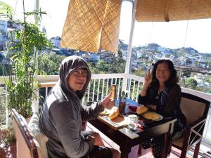 Due donne sedute a un tavolo sul balcone di My Dream Hotel a Da Lat