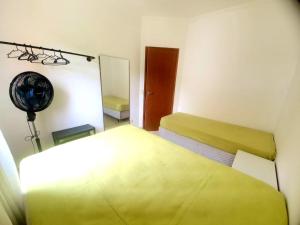 Habitación pequeña con 2 camas y espejo. en Lindo apto com 3 quartos, apenas 1 quadra da praia das Toninhas, en Ubatuba