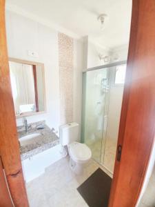 y baño con aseo, lavabo y ducha. en Lindo apto com 3 quartos, apenas 1 quadra da praia das Toninhas, en Ubatuba