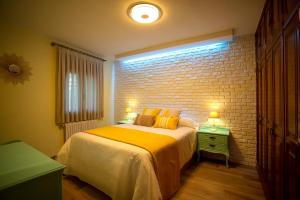 a bedroom with a bed and a brick wall at Casa dos arcos in Sober