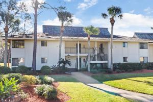 a large white building with palm trees in front of it at Saddlebrook Golf Course view Condo with Kitchen in Wesley Chapel