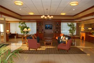 a lobby with couches and chairs and a television at Wyndham Garden Manassas in Manassas