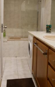 a bathroom with a sink and a washing machine at Beautiful Infante Apartment in Porto
