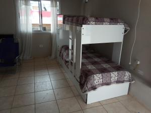 two bunk beds in a room with a tile floor at Luminoso y bello departamento en Carlos Paz in Villa Carlos Paz