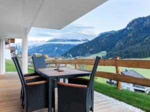 stół i krzesła na werandzie z widokiem na góry w obiekcie Chalet in Wald near Ski Slopes w mieście Wald im Pinzgau
