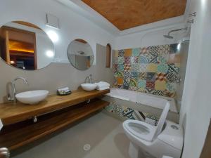 a bathroom with a toilet and a sink and a mirror at La Alhambra Hotel Boutique in Villa de Leyva